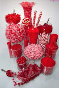 Vistosa mesa de dulces con golosinas rojas y blancas. Vía Pinterest.